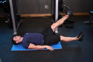 Bărbatul cu prostatită efectuează un exercițiu în sala de gimnastică